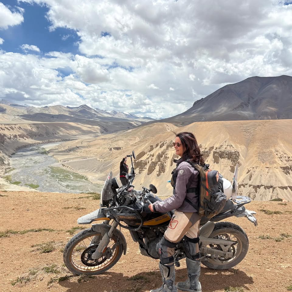 רוכבת אופנוע על רקע נופי הרים במזרח הרחוק